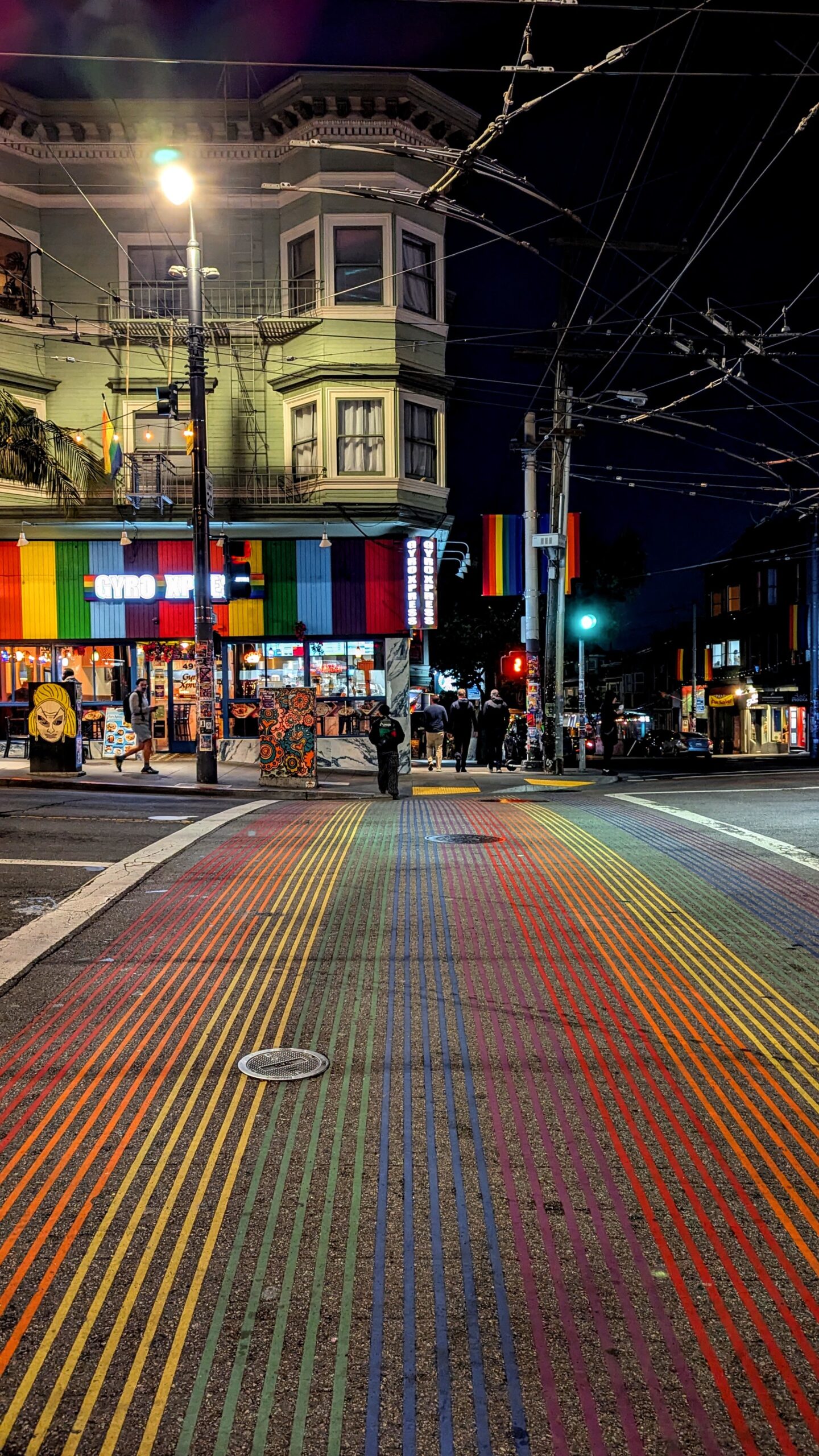 Rainbow crosswalk painted across a street intersection in San Francisco's Castro District